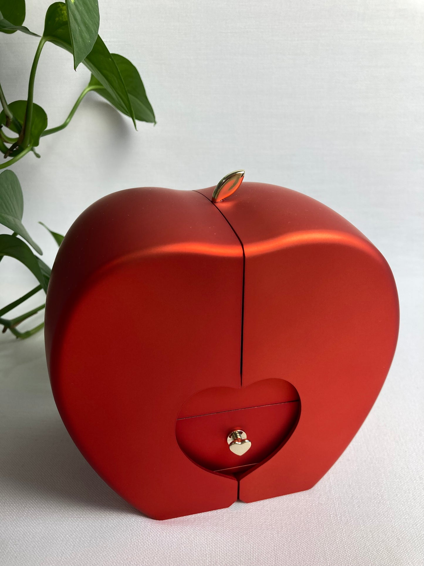 Coffret bijou Modoza fermé en forme de cœur rappelant une pomme, finition rouge élégante avec détail doré
